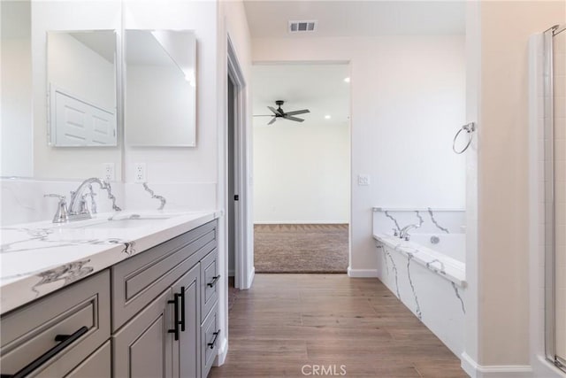 21402 Short Ridge Ave, Perris, CA 92570 - bathroom featuring vanity, ceiling fan, a bath, wood finished floors, and baseboards
