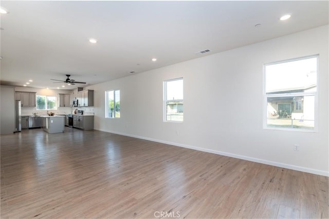 21402 Short Ridge Ave, Perris, CA 92570 - unfurnished living room featuring light wood finished floors, recessed lighting, ceiling fan, and baseboards