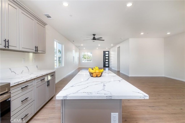 21402 Short Ridge Ave, Perris, CA 92570 - kitchen featuring open floor plan, gray cabinets, light wood finished floors, a kitchen island, and recessed lighting