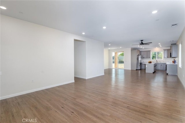 21402 Short Ridge Ave, Perris, CA 92570 - unfurnished living room with recessed lighting, light wood-style flooring, a ceiling fan, and baseboards