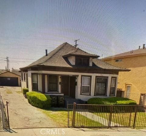 1018 E 57th St, Los Angeles, CA 90011 - bungalow-style home featuring a fenced front yard and a garage