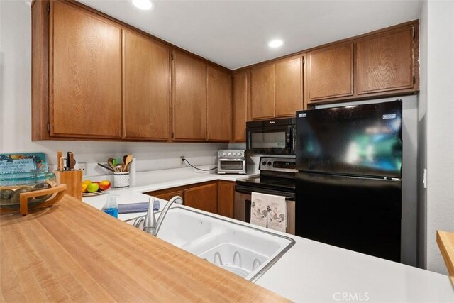 31531 Via Conejo Unit 153, Coto De Caza, CA 92679 - kitchen featuring black appliances, light countertops, a sink, recessed lighting, and brown cabinets