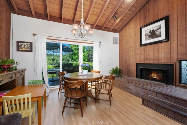 31531 Via Conejo Unit 153, Coto De Caza, CA 92679 - dining space with wood ceiling, light wood finished floors, wooden walls, a fireplace, and a chandelier