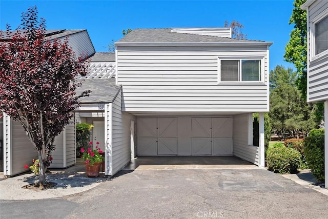 31531 Via Conejo Unit 153, Coto De Caza, CA 92679 - view of home's exterior featuring a shingled roof, an attached garage, and driveway