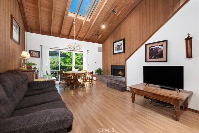 31531 Via Conejo Unit 153, Coto De Caza, CA 92679 - living area with wood ceiling with exposed beams, high vaulted ceiling, a lit fireplace, light wood-type flooring, and a chandelier