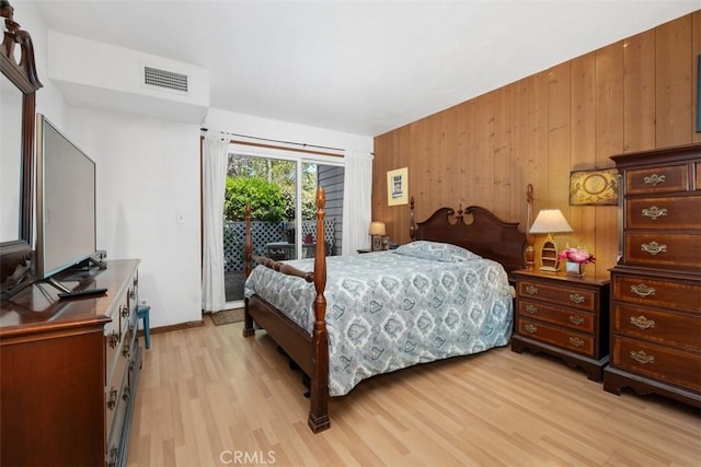 31531 Via Conejo Unit 153, Coto De Caza, CA 92679 - bedroom with access to exterior, light wood-type flooring, and wood walls