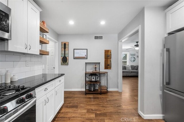 8506 Conway Dr, Riverside, CA 92504 - kitchen with stainless steel appliances, ceiling fan, open shelves, decorative backsplash, and dark wood finished floors