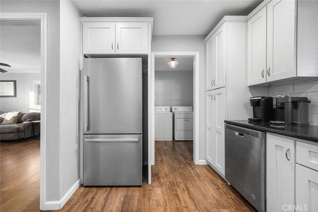 8506 Conway Dr, Riverside, CA 92504 - kitchen featuring stainless steel appliances, washing machine and dryer, wood finished floors, and white cabinets