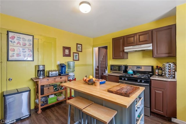471 N Ditman Ave, Los Angeles, CA 90063 - kitchen with under cabinet range hood, appliances with stainless steel finishes, wood counters, dark wood finished floors, and a kitchen breakfast bar