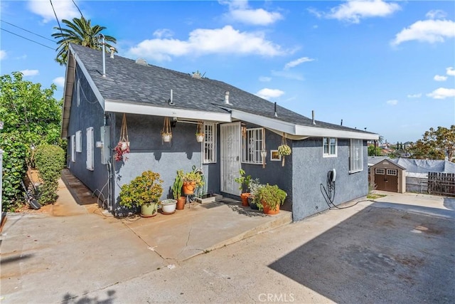 471 N Ditman Ave, Los Angeles, CA 90063 - bungalow with stucco siding, a patio, and roof with shingles