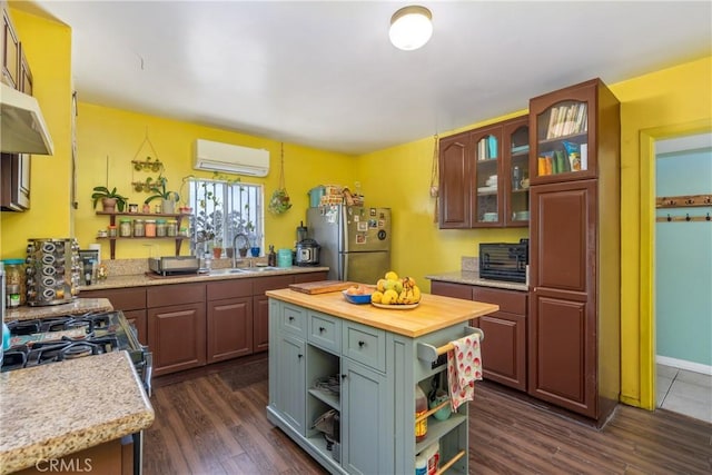 471 N Ditman Ave, Los Angeles, CA 90063 - kitchen with freestanding refrigerator, a wall unit AC, a sink, open shelves, and wood counters