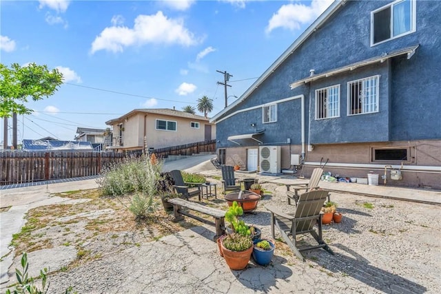 471 N Ditman Ave, Los Angeles, CA 90063 - rear view of house featuring a fire pit, ac unit, a fenced backyard, stucco siding, and a patio area