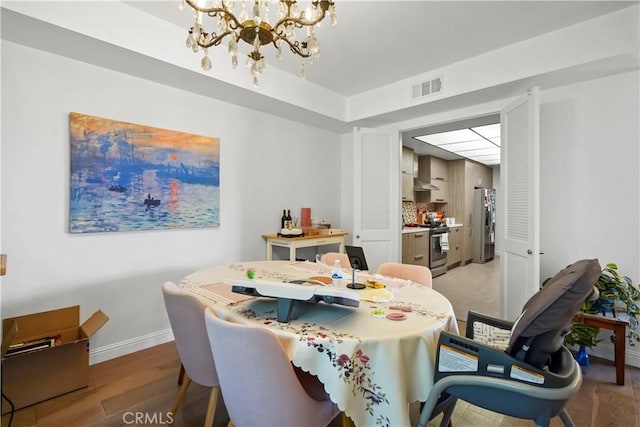 241 S Reeves Dr Unit 302, Beverly Hills, CA 90212 - dining space with a chandelier, light wood-style flooring, and baseboards