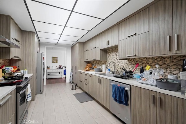 241 S Reeves Dr Unit 302, Beverly Hills, CA 90212 - kitchen featuring stainless steel appliances, light countertops, decorative backsplash, and a sink