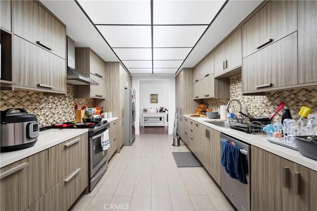 241 S Reeves Dr Unit 302, Beverly Hills, CA 90212 - kitchen with stainless steel appliances, wall chimney range hood, a sink, light countertops, and backsplash