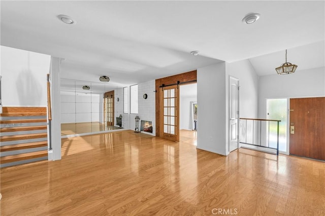 6325 Ridgepath Ct, Rancho Palos Verdes, CA 90275 - unfurnished living room with wood finished floors, stairs, vaulted ceiling, and a barn door
