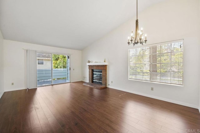 13398 Tiverton Rd, San Diego, CA 92130 - unfurnished living room featuring vaulted ceiling, a brick fireplace, a chandelier, wood finished floors, and baseboards