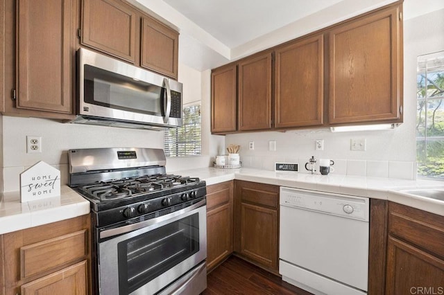 13398 Tiverton Rd, San Diego, CA 92130 - kitchen with stainless steel appliances, healthy amount of natural light, dark wood-style floors, and brown cabinets