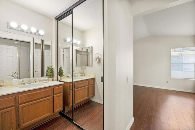 13398 Tiverton Rd, San Diego, CA 92130 - bathroom with two vanities, wood finished floors, baseboards, and vaulted ceiling