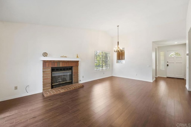 13398 Tiverton Rd, San Diego, CA 92130 - unfurnished living room featuring a chandelier, a brick fireplace, dark wood-style flooring, vaulted ceiling, and baseboards