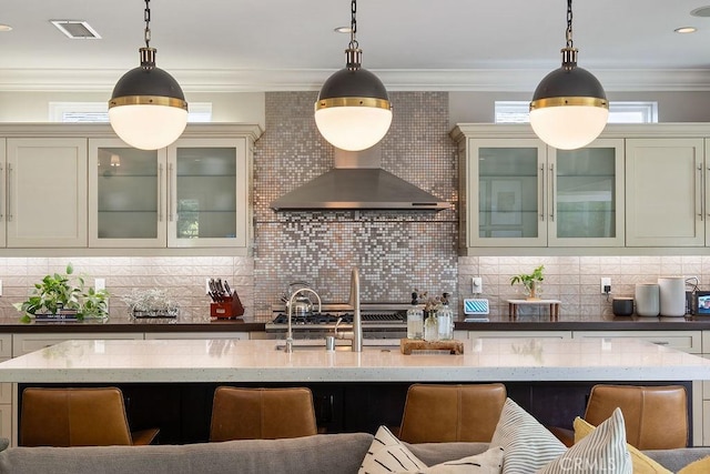 178 Flower St, Costa Mesa, CA 92627 - kitchen featuring decorative backsplash, pendant lighting, light stone countertops, wall chimney range hood, and ornamental molding