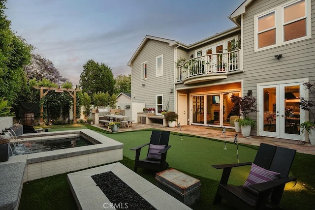178 Flower St, Costa Mesa, CA 92627 - back of house featuring a balcony, a putting green, french doors, an outdoor hot tub, and a patio area
