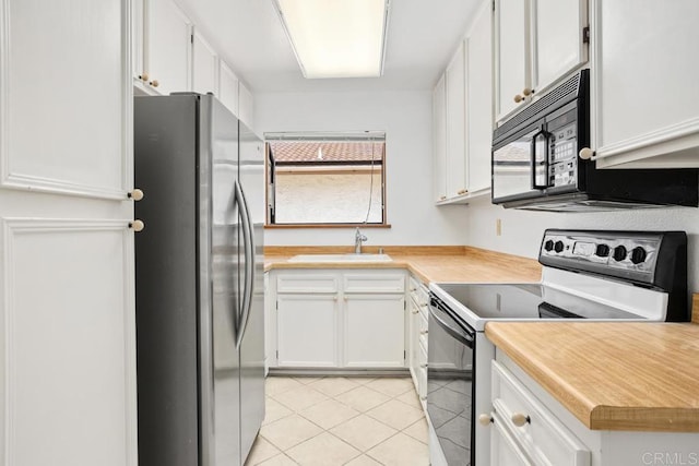 1640 Forestdale Dr, Encinitas, CA 92024 - kitchen with freestanding refrigerator, range with electric cooktop, black microwave, light tile patterned flooring, and white cabinetry