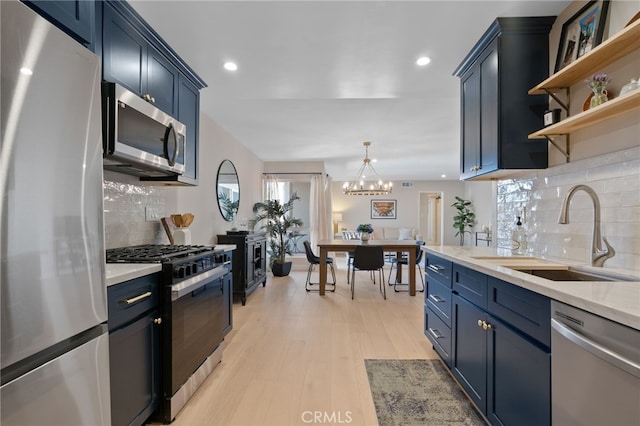 10707 Camarillo St Unit 314, North Hollywood, CA 91602 - kitchen with stainless steel appliances, a sink, blue cabinetry, and recessed lighting