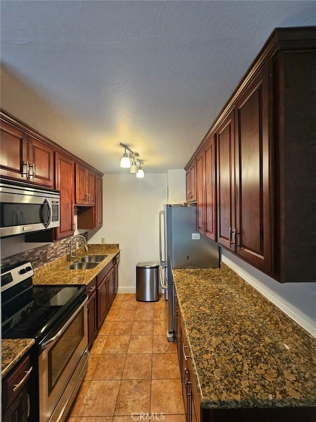 75 Western Shore Ln Unit 1, San Francisco, CA 94115 - kitchen featuring stainless steel appliances, a sink, baseboards, decorative backsplash, and rail lighting