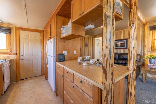 75 Metcalf Creek Trl, Big Bear Lake, CA 92315 - kitchen with stove, freestanding refrigerator, light colored carpet, brown cabinets, and wooden walls