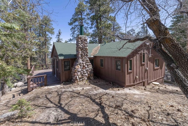 75 Metcalf Creek Trl, Big Bear Lake, CA 92315 - view of side of home with board and batten siding, a shingled roof, a wooden deck, and a chimney