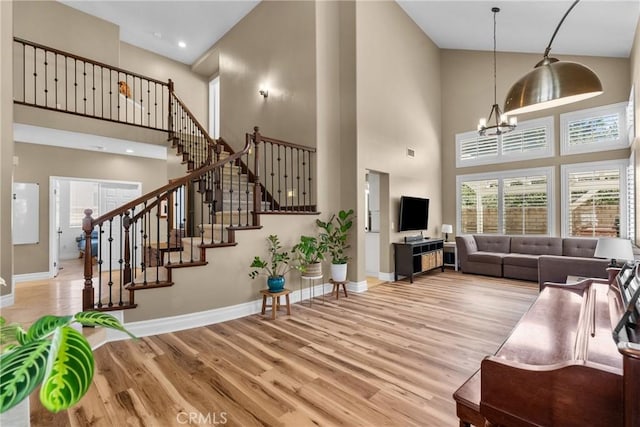 27360 Chesterfield Dr, Valencia, CA 91354 - living area with a towering ceiling, wood finished floors, baseboards, a chandelier, and stairway