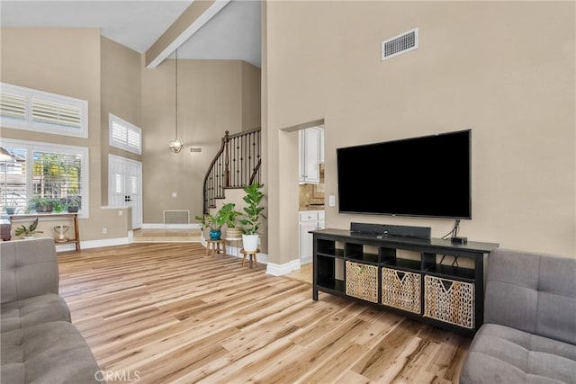 27360 Chesterfield Dr, Valencia, CA 91354 - living area featuring light wood finished floors, high vaulted ceiling, stairs, baseboards, and beam ceiling