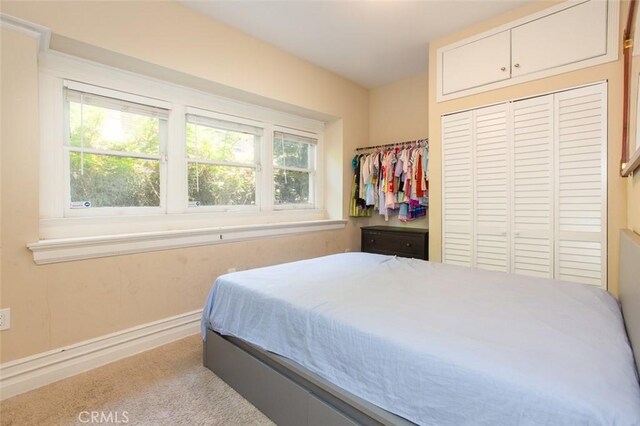 2712 Kenwood Ave, Los Angeles, CA 90007 - bedroom featuring multiple windows, a closet, baseboards, and carpet