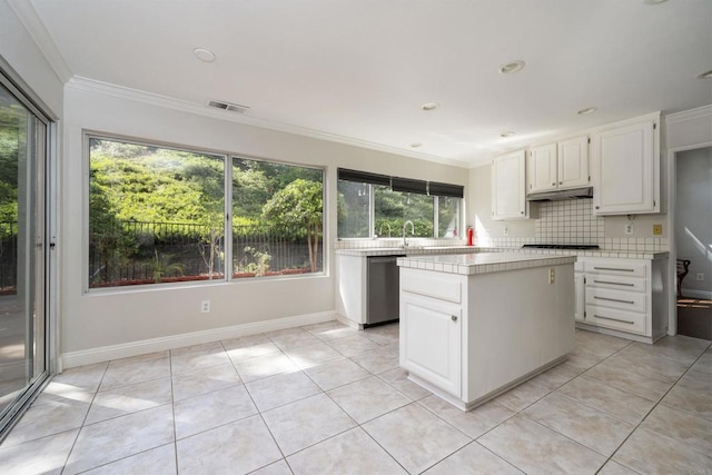 1688 Crystal Ridge Ct, Vista, CA 92081 - kitchen with dishwasher, crown molding, light tile patterned floors, a kitchen island, and decorative backsplash