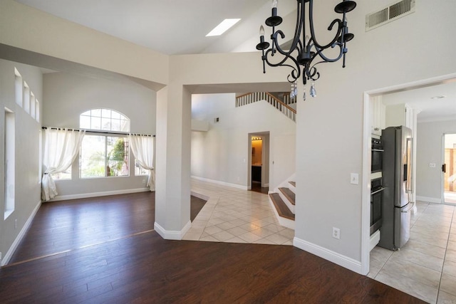1688 Crystal Ridge Ct, Vista, CA 92081 - spare room with stairs, high vaulted ceiling, a chandelier, light wood-style flooring, and baseboards