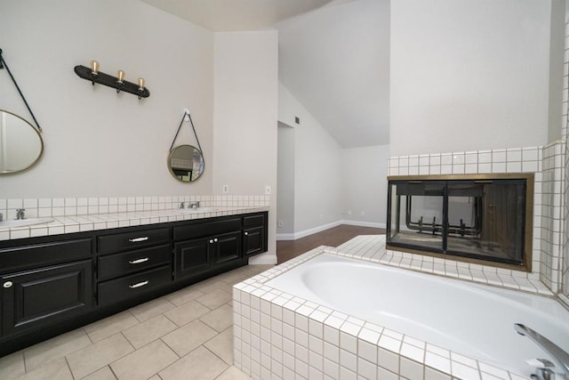1688 Crystal Ridge Ct, Vista, CA 92081 - bathroom featuring double vanity, a garden tub, lofted ceiling, and tile patterned flooring