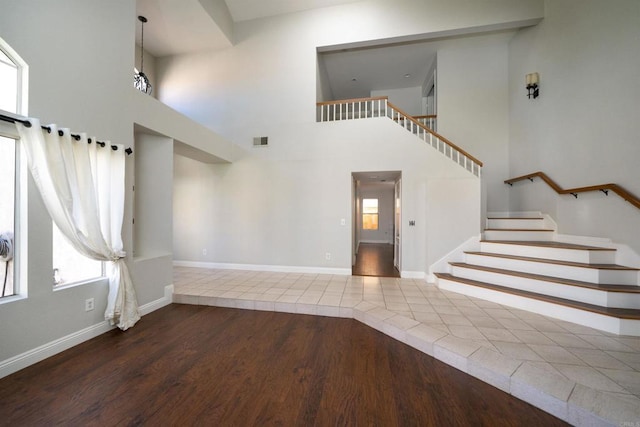 1688 Crystal Ridge Ct, Vista, CA 92081 - unfurnished living room featuring stairway, a high ceiling, wood finished floors, and baseboards
