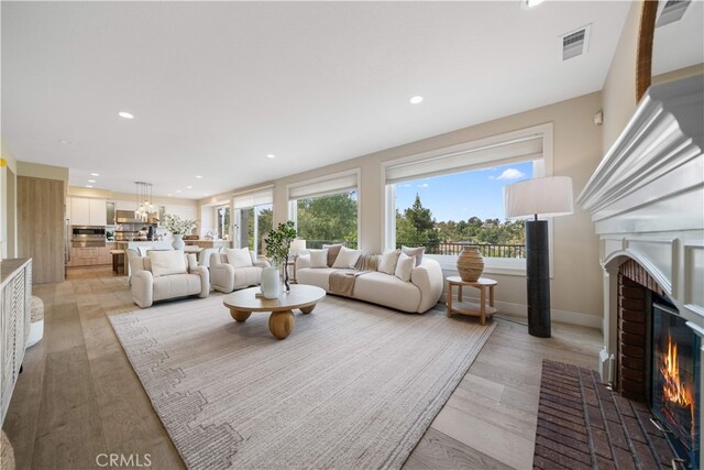 3048 Street Of The Chimes, Chino Hills, CA 91709 - living room with a brick fireplace, healthy amount of natural light, recessed lighting, and light wood finished floors
