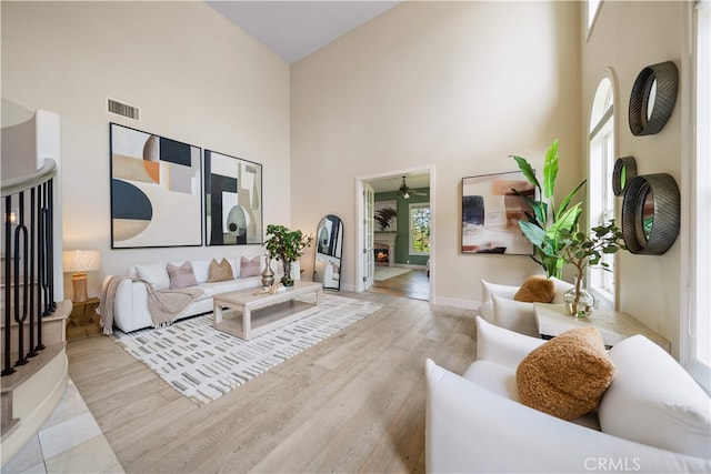 3048 Street Of The Chimes, Chino Hills, CA 91709 - living area with a high ceiling, ceiling fan, wood finished floors, and a warm lit fireplace