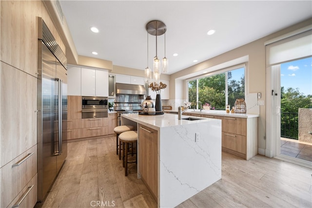 3048 Street Of The Chimes, Chino Hills, CA 91709 - kitchen featuring modern cabinets, built in appliances, a warming drawer, under cabinet range hood, and light stone counters