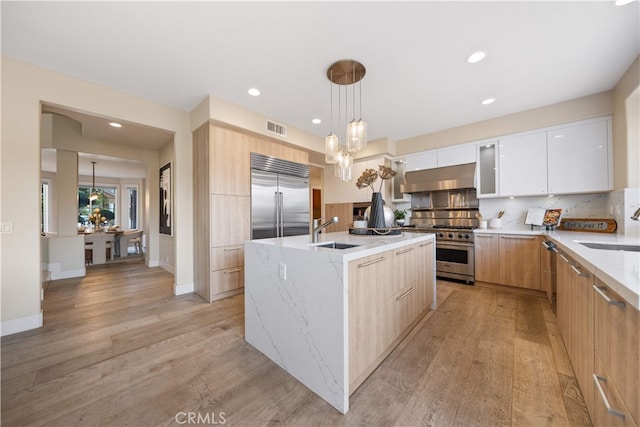3048 Street Of The Chimes, Chino Hills, CA 91709 - kitchen with high quality appliances, ventilation hood, modern cabinets, light wood-style floors, and tasteful backsplash