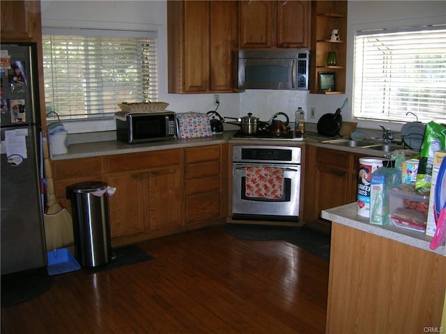 8358 Murietta Ave, Panorama City, CA 91402 - kitchen with appliances with stainless steel finishes, a sink, brown cabinetry, and light countertops