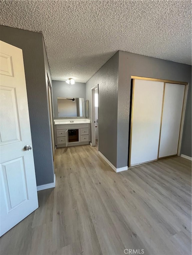 14199 Havasu Rd, Apple Valley, CA 92307 - unfurnished living room with a textured ceiling, light wood-style flooring, and baseboards