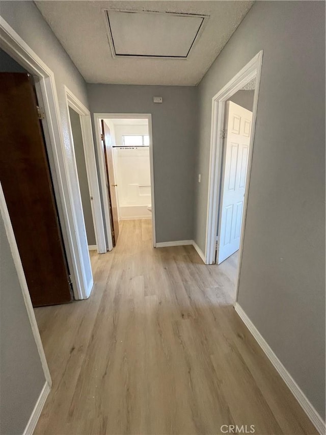 14199 Havasu Rd, Apple Valley, CA 92307 - corridor featuring light wood-style flooring, baseboards, and attic access