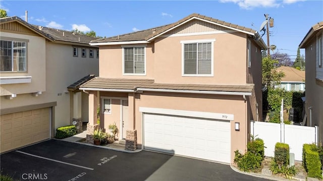 1972 W Blue Violet Ct, Anaheim, CA 92801 - view of front of house with an attached garage, a tiled roof, and stucco siding