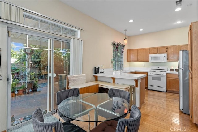 1972 W Blue Violet Ct, Anaheim, CA 92801 - kitchen featuring white appliances, a peninsula, light countertops, light wood-type flooring, and recessed lighting
