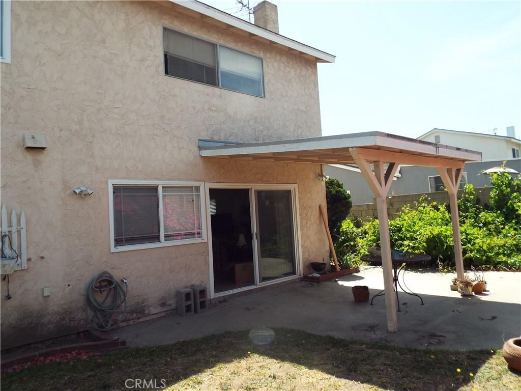 1311 Woodbury Dr, Harbor City, CA 90710 - rear view of house with a patio, stucco siding, and a chimney