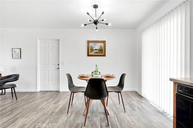 22331 Ramona Ave, Apple Valley, CA 92307 - dining room featuring a chandelier, light wood-style flooring, and baseboards