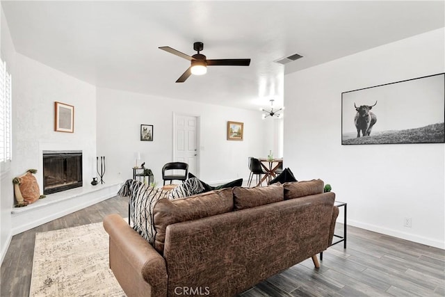 22331 Ramona Ave, Apple Valley, CA 92307 - living room with ceiling fan, wood finished floors, a glass covered fireplace, baseboards, and a chandelier
